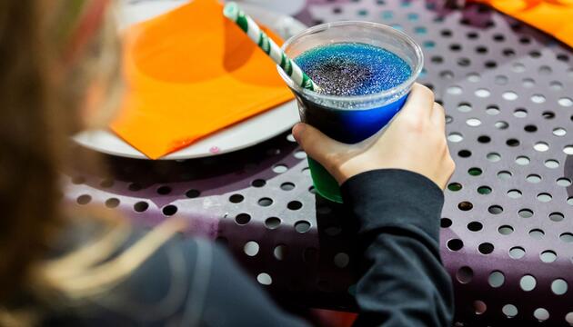 Kind trinkt ein Slush-Eis bei einem Kindergeburtstag