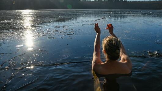 Frau geht in einem Loch im Eis baden