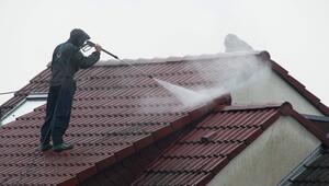 Arbeiter reinigen das Dach eines Hauses