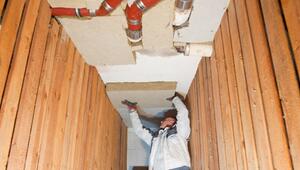 Ein Mann dämmt eine Kellerdecke