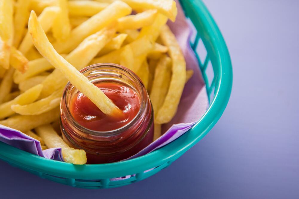 Pommes mit Ketchup wird in einem Körbchen serviert