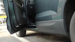 Auto parkt mit offener Autotür am Straßenrand