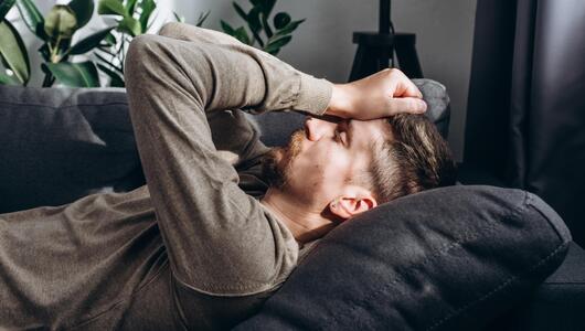 Mann Sofa Frust Kopfschmerzen