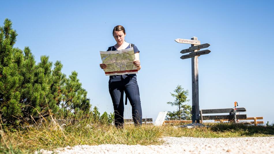 Wanderin schaut auf eine Wanderkarte