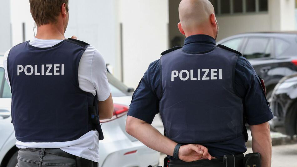 Polizisten stehen am Samstag am Tatort in Maria Alm.