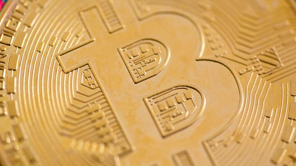 Eine Bitcoin-Münze liegt auf einem Tisch. (Symbolbild)