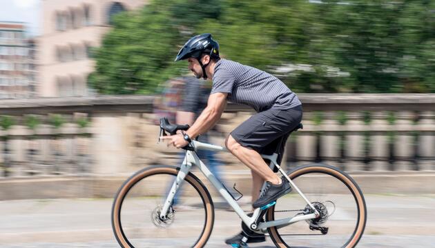 Mann fährt mit einem Gravelbike durch die Stadt