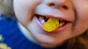 Ein Kind beißt auf ein Gummibärchen