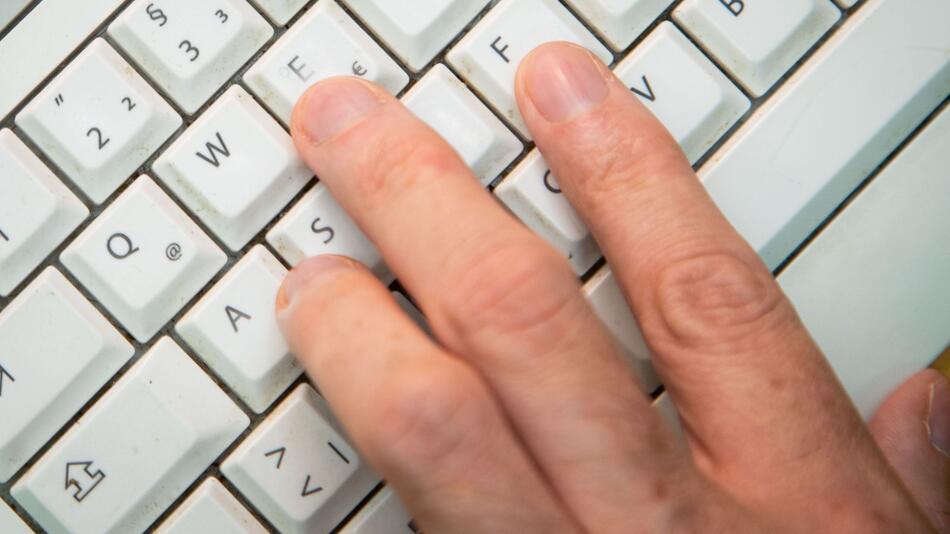 Mann tippt auf einer Tastatur