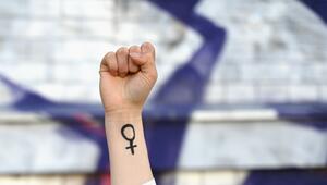 Eine Frau hebt ihre Faust mit Venussymbol die Höhe