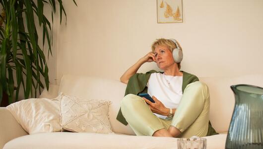 Eine Frau sitzt nachdenklich auf einem Sofa