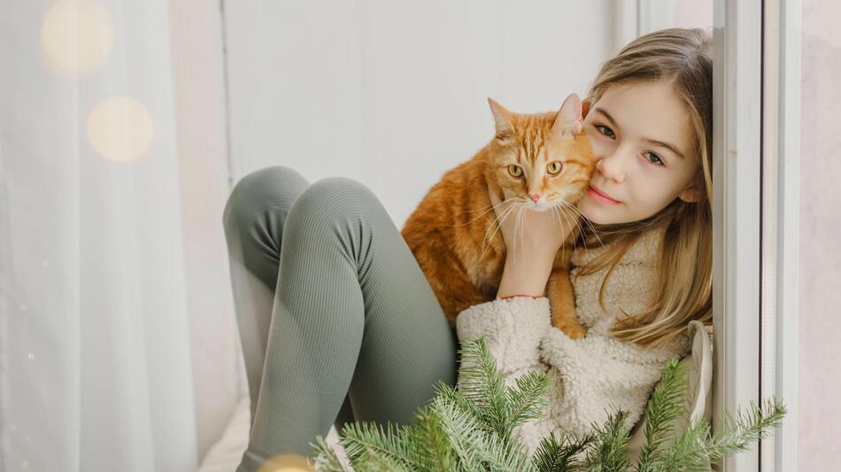 Mädchen schmust mit Katze
