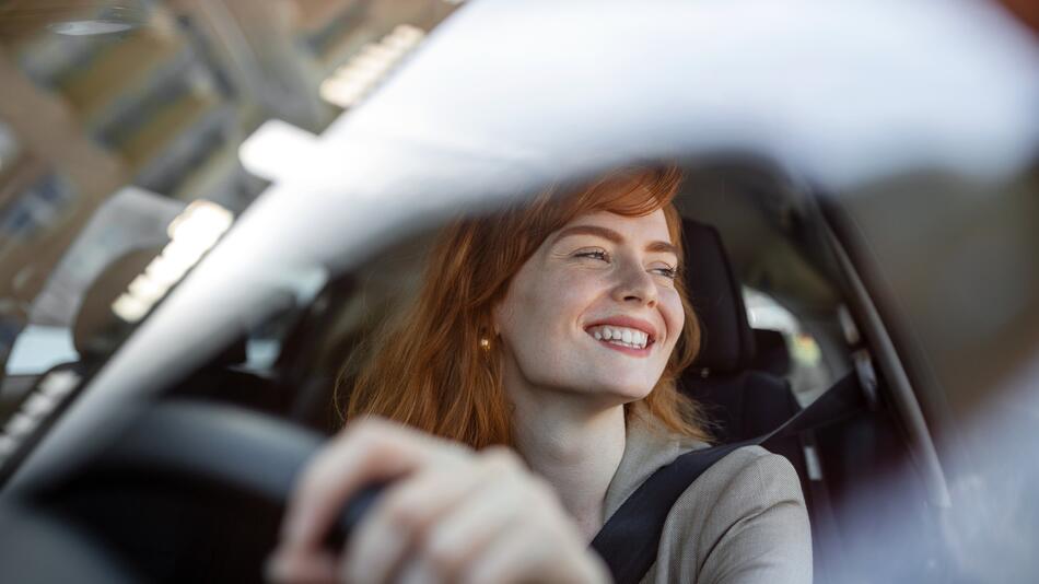 Eine Frau sitzt am Steuer eines Autos.