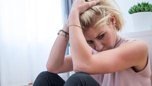 Junge Frau sitzt traurig auf dem Fußboden einer Wohnung