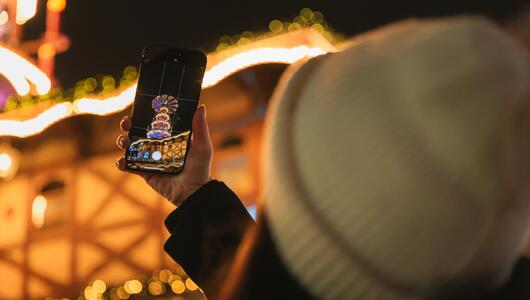 Person fotografiert Weihnachtsmarkt