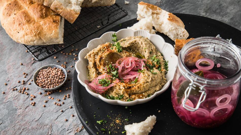 Hummus und Fladenbrot stehen auf einem Tisch