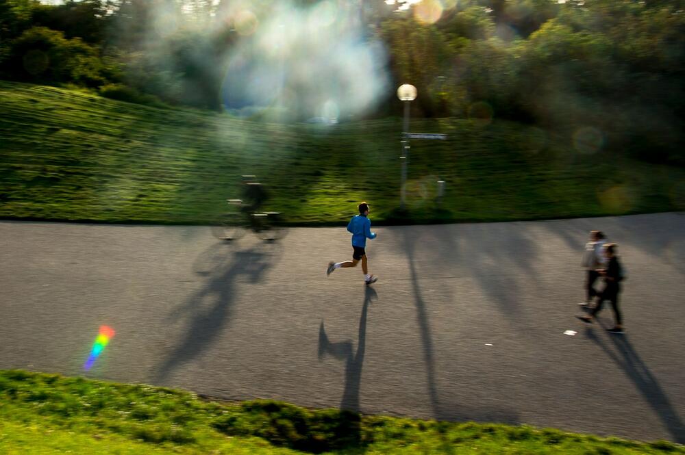 Ein Mann joggt durch den Olympia-Park in München