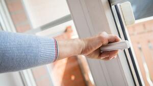 Eine Frau öffnet ein Fenster