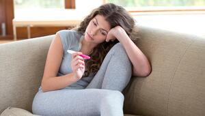 Frau schaut traurig auf Schwangerschaftstest