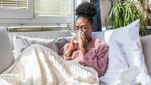 Frau ist erkältet zu Hause
