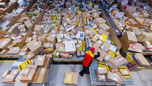 Paketzusteller sortiert in einer Zustellbasis Pakete