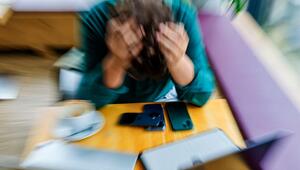 Ein Mann stützt am Arbeitsplatz seinen Kopf mit den Händen