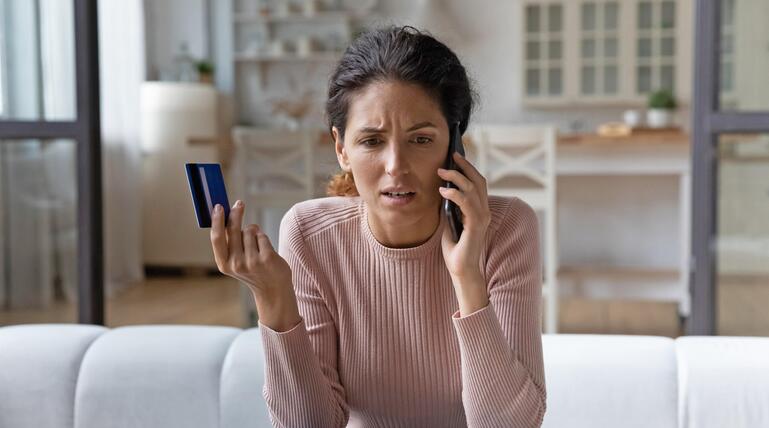 Frau geschockt am Telefon