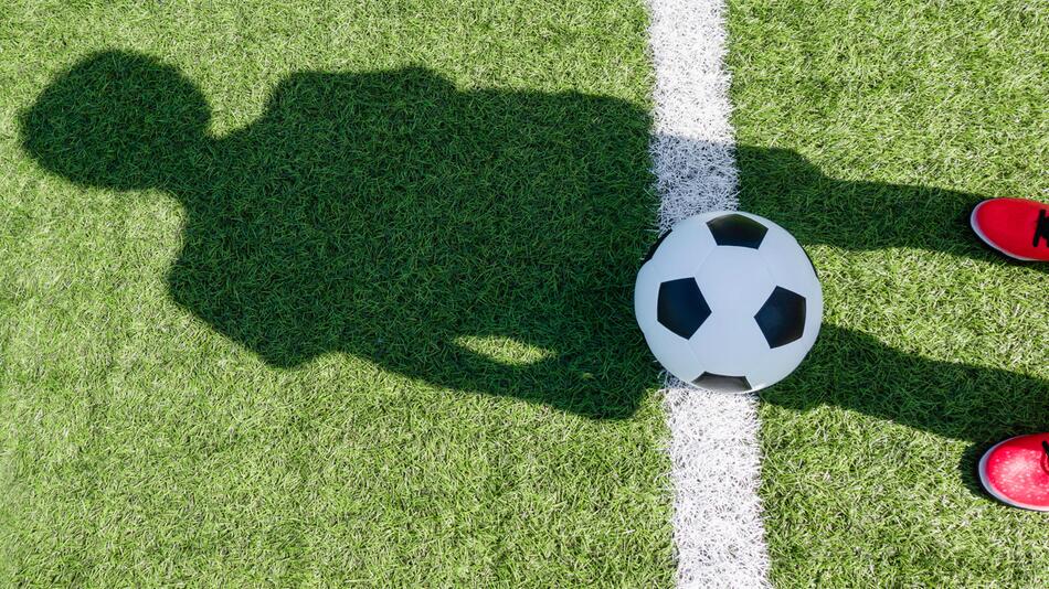 Schatten eines Kindes auf dem Fußballfeld