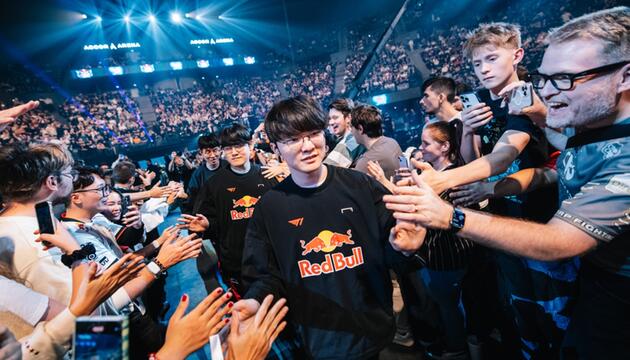 Das "League of Legends"-Team T1 läuft durch eine Menge jubelnder Menschen in einem großen Stadion.