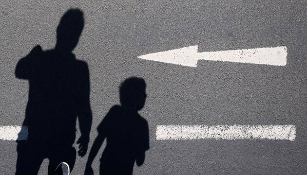 Schatten von einem Mann und einem Kind sind auf einer Straße