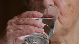 Ältere Frau trinkt ein Glas Wasser