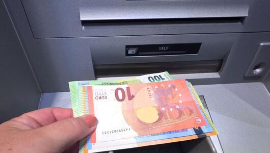 Frau hebt Geld an einem Geldautomaten ab