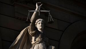 Vor einem Justizgebäude steht die Statue einer Justitia