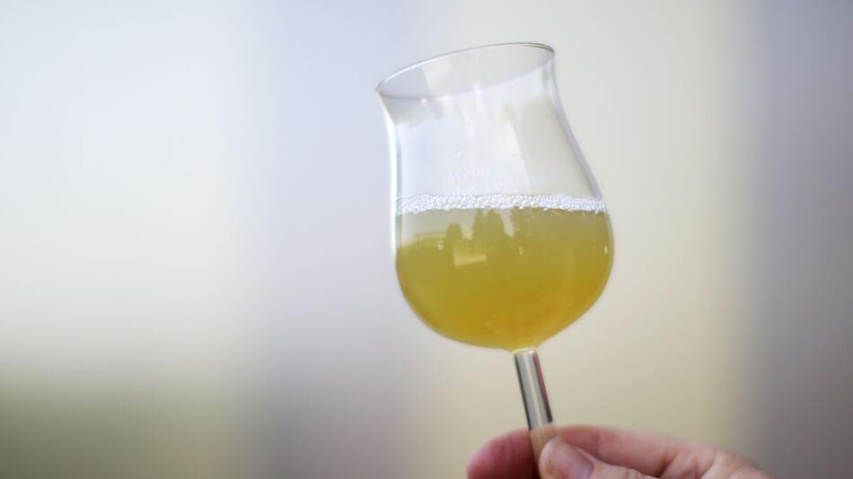 Eine Frau hält ein Glas mit Traubensaft in der Hand