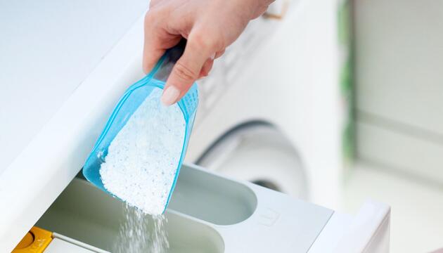 Waschmittelpulver wird in eine Waschmaschine gefüllt