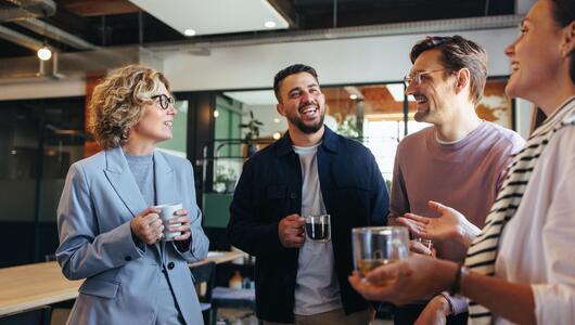 Kollegen machen gemeinsam Kaffeepause im Büro