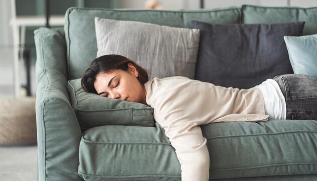 Frau liegt auf der Couch