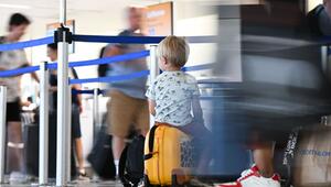 Ein Junge wartet vor einem Check-In-Schalter