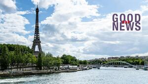 Eiffelturm in Paris, umgeben von Bäumen, mit der Seine im Vordergrund und einer Brücke im ...