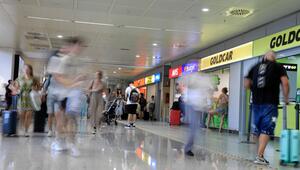 Menschen gehen am Flughafen an Mietwagen-Firmen vorbei