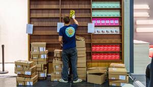 Ein junger Mann räumt Bücher in ein Regal ein
