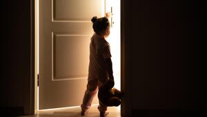 Kind im Schlafanzug öffnet eine Tür