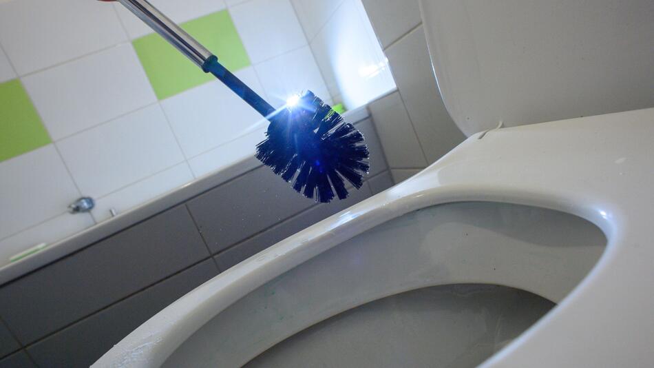 Eine glänzende Klobürste über einer Toilettenschüssel