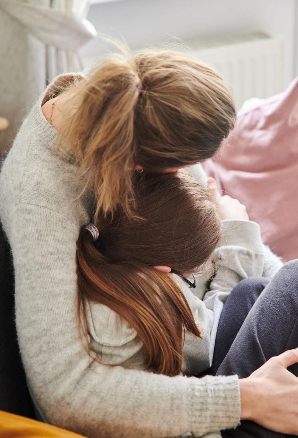Mutter tröstet Mädchen