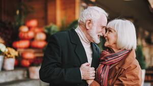 Paar mit grauen Haaren, das sich umarmt und nah zusammen steht. 