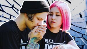 Junges Paar, er küsst ihre Hand. Sie hat pinke Haare. 