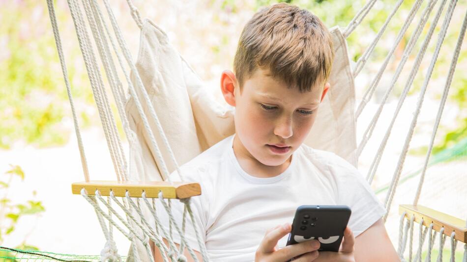 Junge schaut auf sein Smartphone
