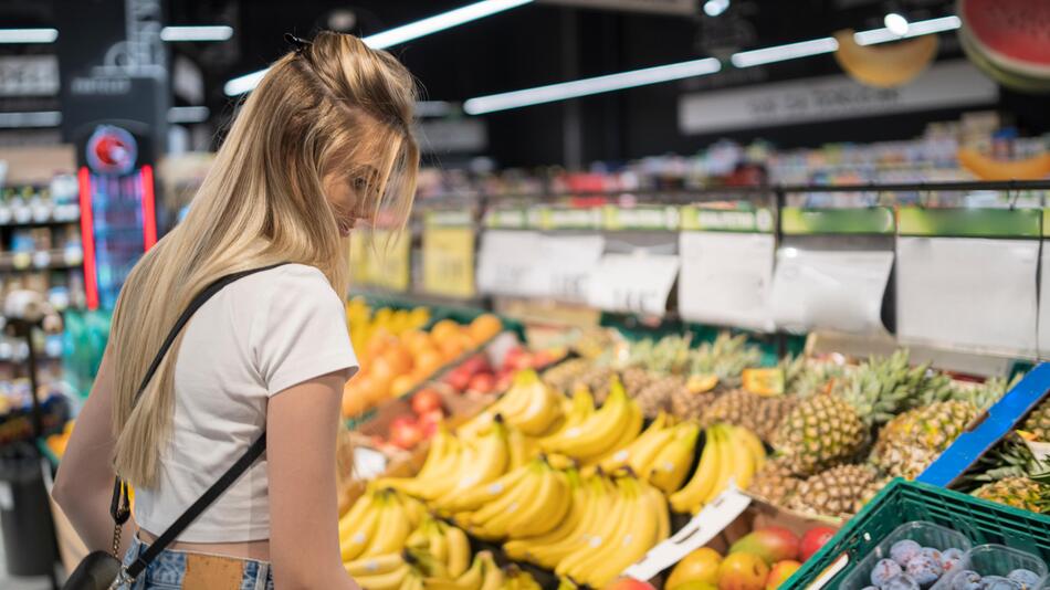 Eine Kundin geht in einem Supermarkt einkaufen
