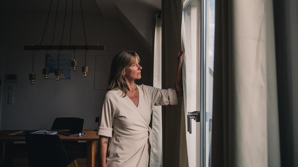 Frau schaut aus einem Fenster
