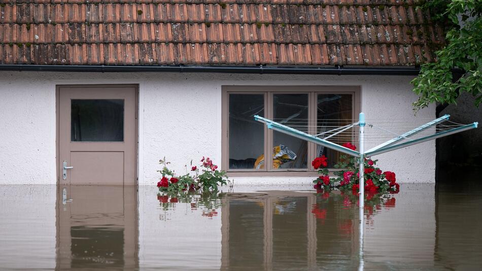 Von Hochwasser überfluteter Garten vor einem Haus